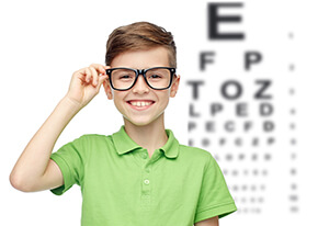 Child with glasses taking an eye exam