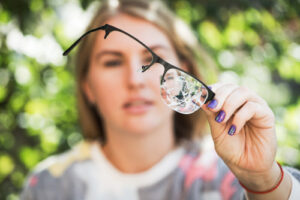 woman holding broken glasses